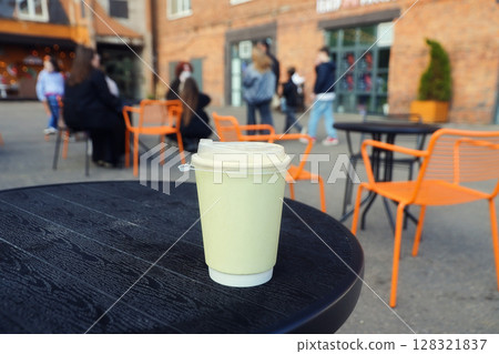 paper creamy color cup of drink on black table on cafe street 128321837