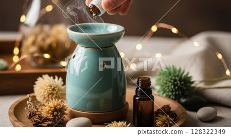 Hand Adding Essential Oil to Boho Diffuser 128322349