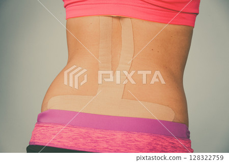 Woman with medical kinesio taping on back 128322759