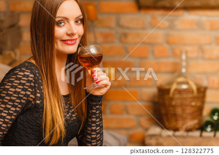 Woman tasting wine in rural cottage interior Woman tasting wine in rural cottage interior 128322775