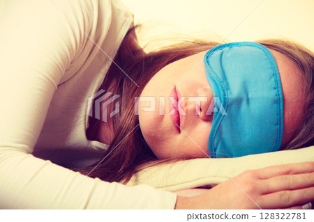Brunette woman sleeping in blue eye sleep mask 128322781