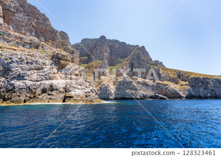 Rocky cliffs meet the turquoise sea on a sunny day in Marettimo, Sicily Rocky cliffs meet the turquoise sea on a sunny day in Marettimo, Sicily 128323461