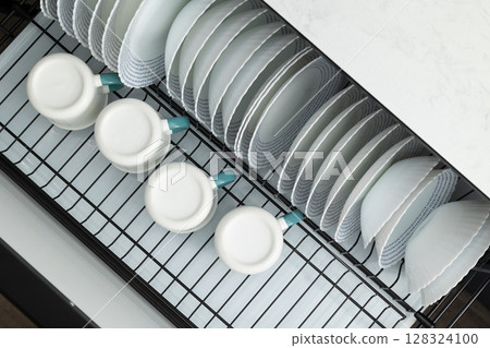 Clean Dishes Neatly Organized on a Drying Rack After Washing in a Modern Kitchen 128324100