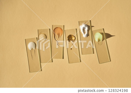 Samples of multi-colored cosmetic products on a beige background. 128324198