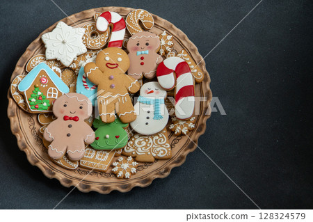 Gingerbread cookies decorated. Christmas sweet food. Gingerbread man baking. Xmas treats on black background copy space Gingerbread cookies decorated. Christmas sweet food. Gingerbread man baking. Xmas treats on black background copy space 128324579