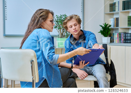 Woman school psychologist talking and helping student, male teenager Woman school psychologist talking and helping student, male teenager 128324633