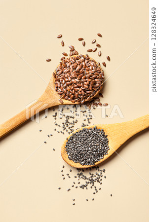 Flaxseeds and chia seeds on spoons 128324649