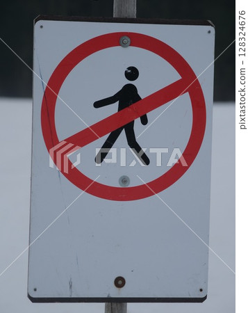 Sign that says no walking is on a pole 128324676