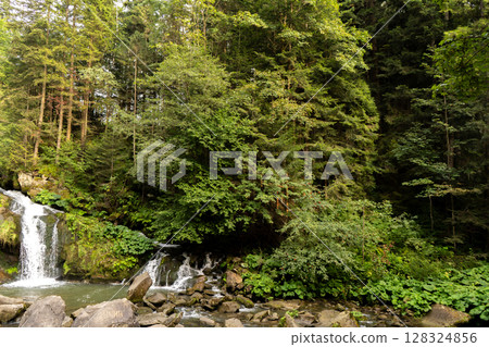 Mountain waterfall in the forest. Green nature. Mountain waterfall in the forest. Green nature. 128324856
