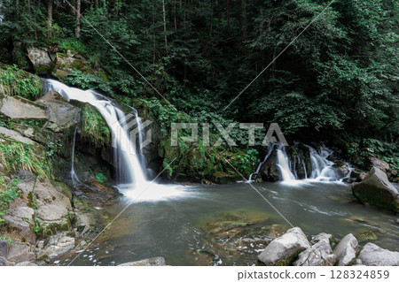 Mountain waterfall in the forest. Green nature. Mountain waterfall in the forest. Green nature. 128324859