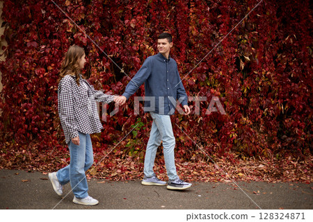 Young Cute Female Hugs Boyfriend. In Autumn Outdoor. Lovers Walking in Park. Attractive Funny Couple. Lovestory in Forest. Man and Woman. Cute Lovers in the Park. Family Concept. Happy Couple. 128324871