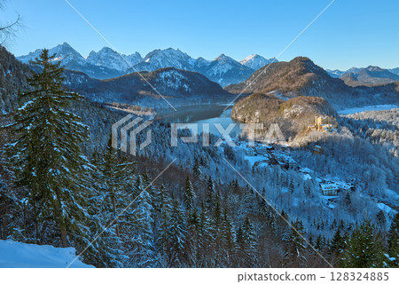 Beautiful winter morning landscape with snowy mountains and a serene lake, icy landscape surrounding majestic peaks, dawn light in January Beautiful winter morning landscape with snowy mountains and a serene lake, icy landscape surrounding majestic peaks, dawn light in January 128324885