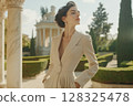 Elegant woman in beige attire against classic architectural background 128325478