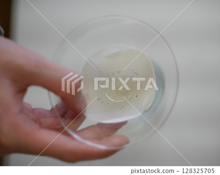 Person is pouring a liquid into a glass 128325705