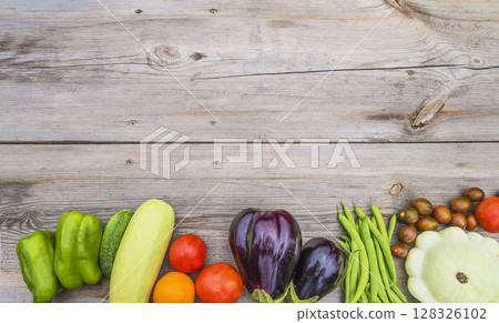 Frame of fresh raw season vegetables (cucumber, bell pepper, tomato, cabbage, eggplants, green beans) on a wooden background; copy space Frame of fresh raw season vegetables (cucumber, bell pepper, tomato, cabbage, eggplants, green beans) on a wooden background; copy space 128326102