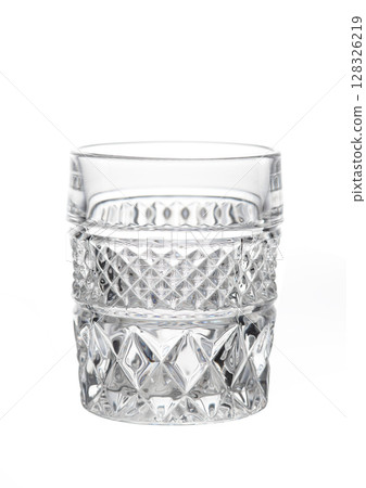 Close-up of an empty cut crystal glass with textured pattern, isolated on white background. 128326219