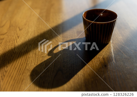 Silhouette of a coffee cup on a table 128326226
