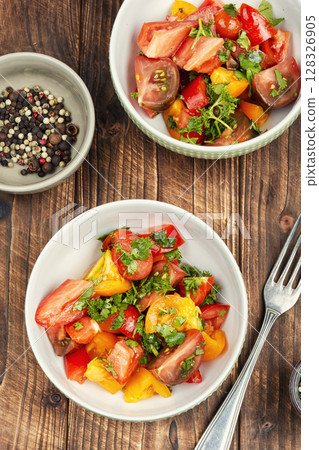 Fresh salad preparation with tomatoes and greens. Fresh salad preparation with tomatoes and greens. 128326905