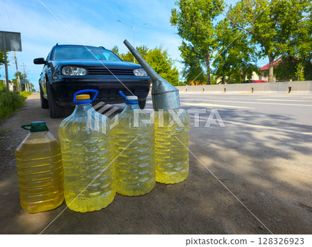 car stopped in front of by plastic bottles with gasoline on the side of the road car stopped in front of by plastic bottles with gasoline on the side of the road 128326923