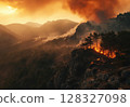A fierce forest fire rages on a hillside in Turkey, with flames consuming trees and thick smoke billowing against a warm sunset backdrop. 128327098