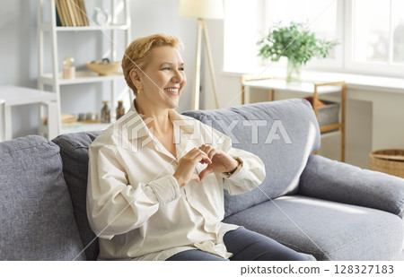 Elderly Woman Showing Heart Sign With Hands At Home 128327183