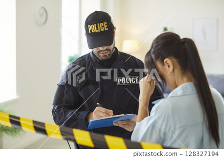 Policeman making victim interview after burglary interrogating a young woman. 128327194