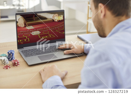 Online casino computer laptop male gambler playing, wager on casino games through Internet 128327219