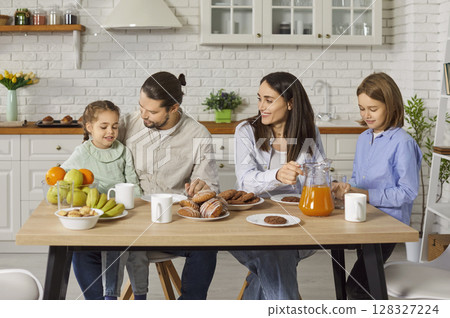 Happy family gathering in kitchen at home together having a breakfast. 128327224