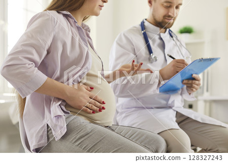 Young woman who is expecting baby is talking to her obstetrician or gynecologist 128327243