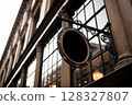 Historic Building Facade with Vintage Oval Signage Hanging Prominently 128327807