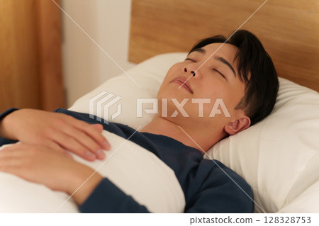 晚上在床上睡覺的男人 128328753
