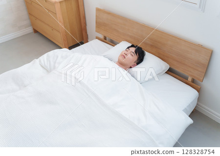 Man sleeping in bed in the morning 128328754