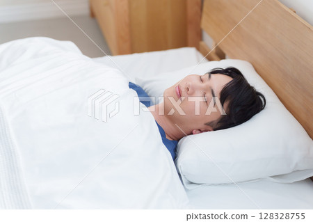 Man sleeping in bed in the morning 128328755