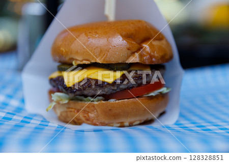 Deliciously Juicy Cheeseburger Elevated by Fresh Vegetables and Tasty Condiments, Perfect for a Satisfying Meal at Any Time of Day or Night, Loaded with Flavor and Texture 128328851