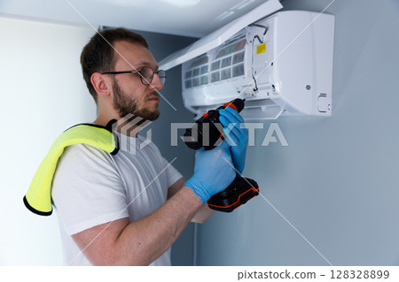 Man Installing Air Conditioning Unit: Guide to HVAC Maintenance and Home Comfort Solutions for Optimal Indoor Climate Control Man Installing Air Conditioning Unit: Guide to HVAC Maintenance and Home Comfort Solutions for Optimal Indoor Climate Control 128328899