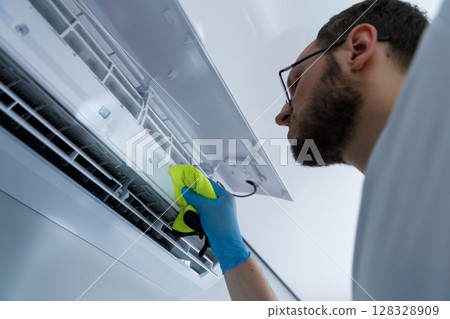 Professional air conditioner maintenance and cleaning for optimal performance and air quality to ensure a comfortable indoor environment for homes and businesses alike. 128328909