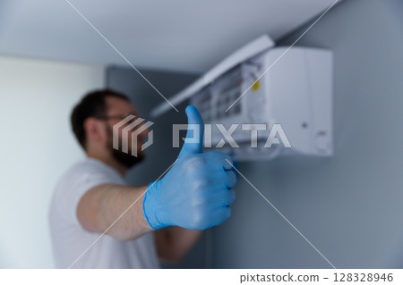 Skilled Technician Giving Approval After Successfully Installing a New Air Conditioning Unit for Optimal Cooling in a Modern Home Environment 128328946