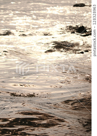Captivating Reflections on Water: A Serene Scene Captured in Glimmering Waves Under the Golden Hour Light Enhancing Nature s Beauty 128328963