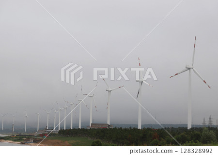 A Scenic View of Modern Wind Turbines Against a Cloudy Sky, Highlighting Sustainable Energy Solutions and Their Importance in Combating Climate Change and Promoting Green Technology A Scenic View of Modern Wind Turbines Against a Cloudy Sky, Highlighting Sustainable Energy Solutions and Their Importance in Combating Climate Change and Promoting Green Technology 128328992
