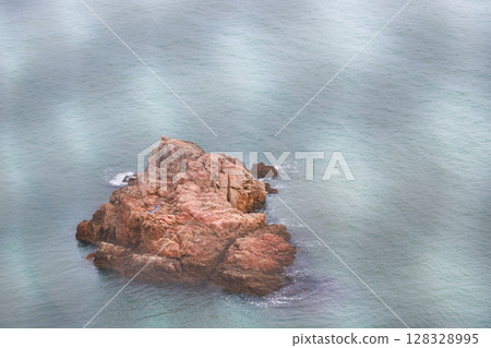 Scenic View of a Rocky Island Surrounded by Calm Waters Emphasizing Nature's Beauty and Tranquility in a Serene Coastal Landscape 128328995
