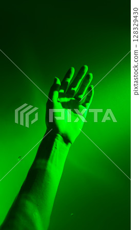 A Stunning Capture of a Hand Reaching Up in a Vibrant Green Atmosphere Evoking Mystical and Ethereal Themes of Growth and Connection with Nature's Elements 128329430