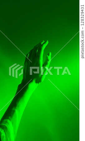 A Glimpse of Serenity and Mystery: An Artistic Representation of a Human Hand Reaching Towards an Ethereal Green Illumination A Glimpse of Serenity and Mystery: An Artistic Representation of a Human Hand Reaching Towards an Ethereal Green Illumination 128329431
