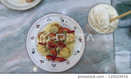 Delicious Dessert Spread: Creamy Custard with Fresh Strawberries, Crunchy Nuts, and a Side of Refreshing Ice Cream in Charming Table Setting 128329438