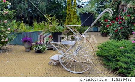 Charming Garden Scene Featuring a Vintage Wheelbarrow Surrounded by Colorful Floral Arrangements and Lush Greenery in a Peaceful Outdoor Setting 128329488