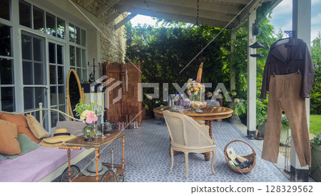 Charming Outdoor Patio Setting with Vintage Decor and Cozy Seating for Relaxation and Socializing in a Serene Garden Environment 128329562