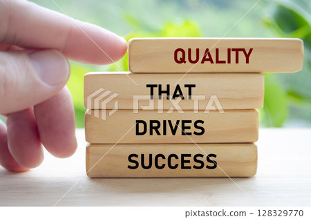 Quality that drives success text on wooden blocks being pushed forward symbolizes how excellence leads to real achievement Quality that drives success text on wooden blocks being pushed forward symbolizes how excellence leads to real achievement 128329770