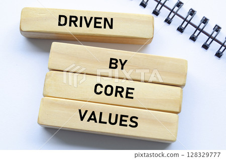 Driven by core values text on wooden blocks and notebook represents purposeful direction guided by foundational beliefs 128329777
