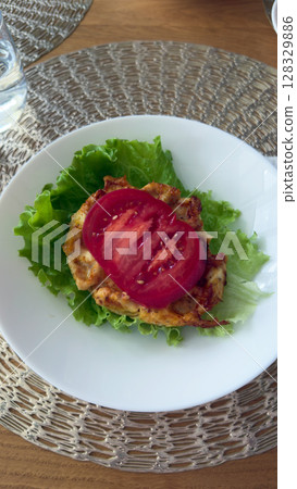 Deliciously Simple Chicken Salad Plate with Fresh Lettuce and Juicy Tomato Slices for a Healthy and Flavorful Dining Experience 128329886