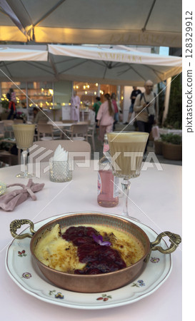 Delicious Dessert with Delicate Cherry Sauce Served in a Charming Outdoor Caf Setting Perfect for Relaxing and Enjoying Quality Time with Friends and Family 128329912