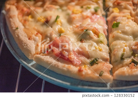 Ready-made pizza with bacon and cheese on a blue plate. Ready-made pizza with bacon and cheese on a blue plate. 128330152